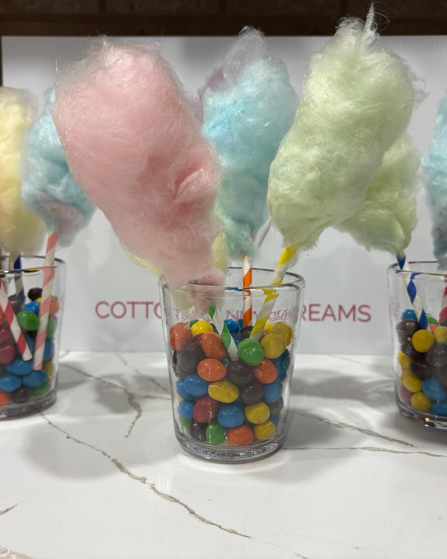 Colorful cotton candy party favors presented in candy-filled cups