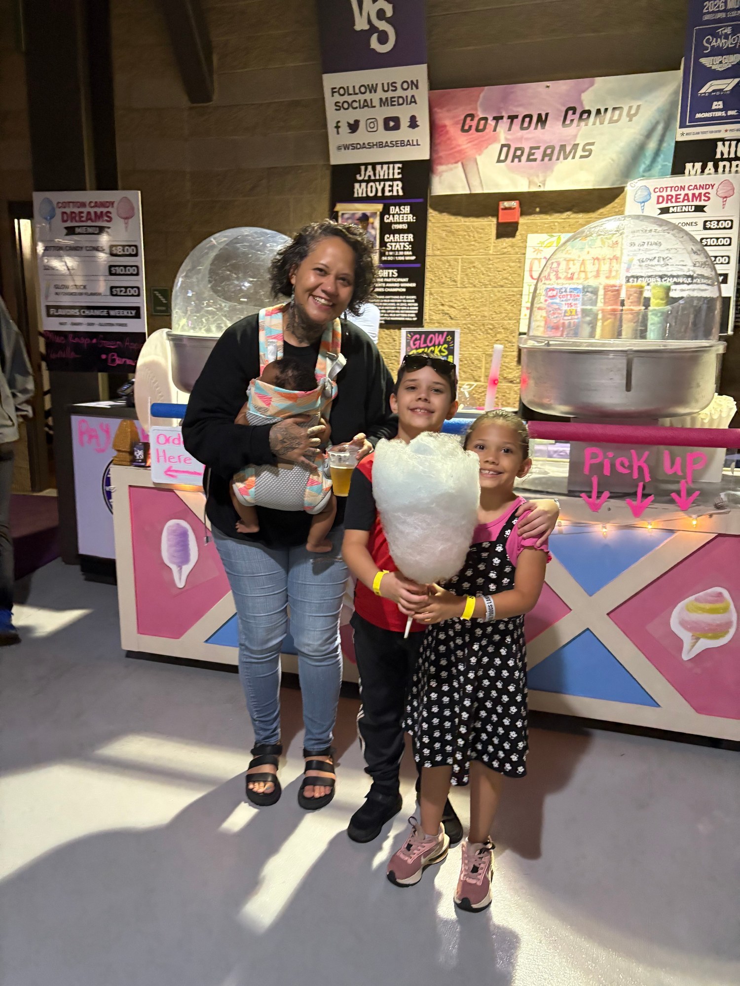 Family visiting the Cotton Candy Dreams booth at a Winston-Salem Dash game