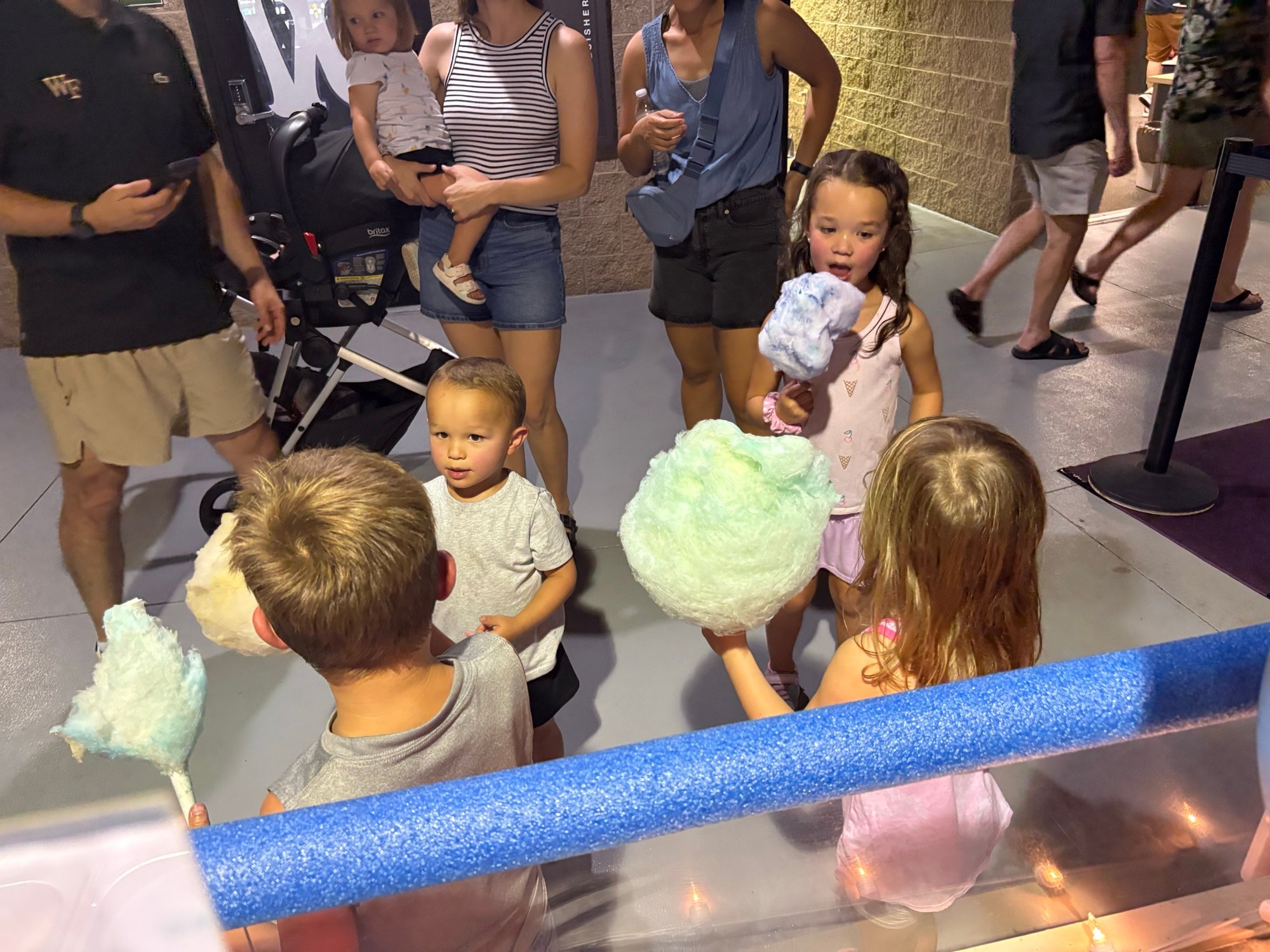 Children enjoying colorful cotton candy at a Winston-Salem Dash game