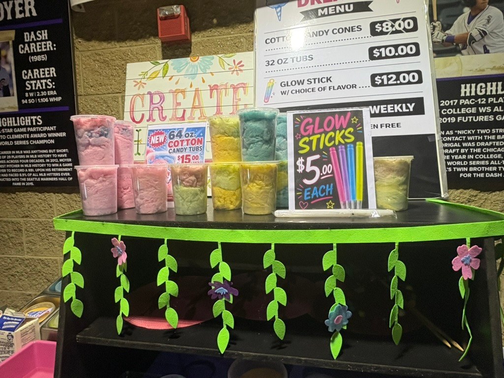 Colorful cotton candy tubs and glow sticks displayed at a Winston-Salem Dash game