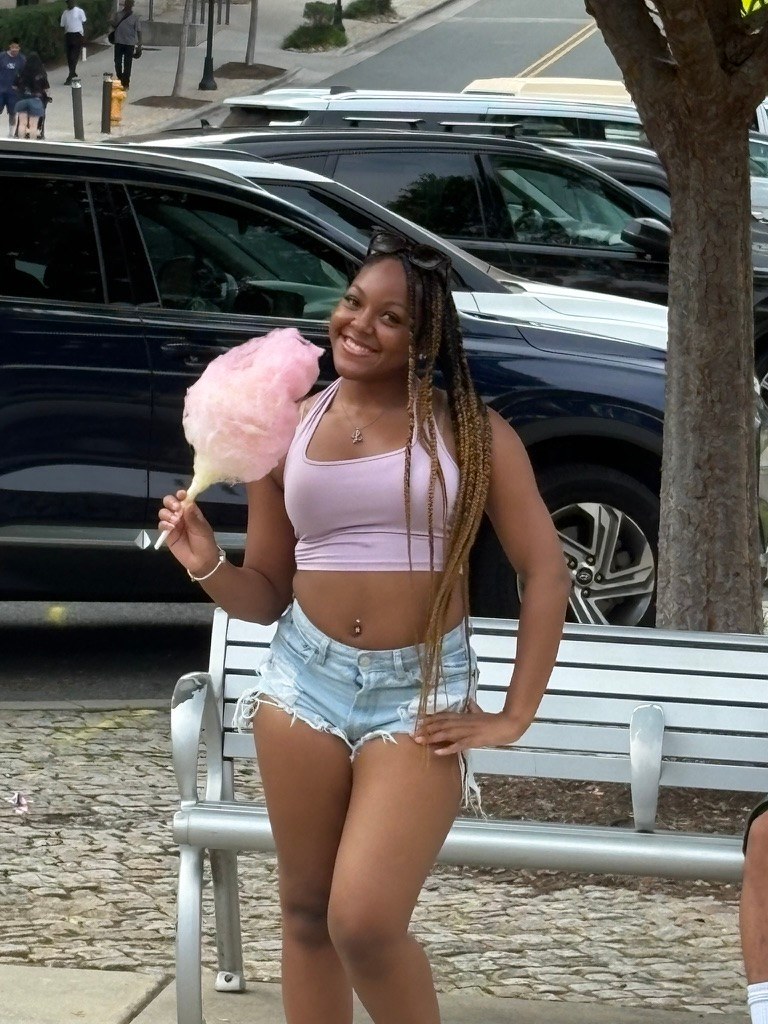 Guest enjoying a large pink cotton candy at a community event