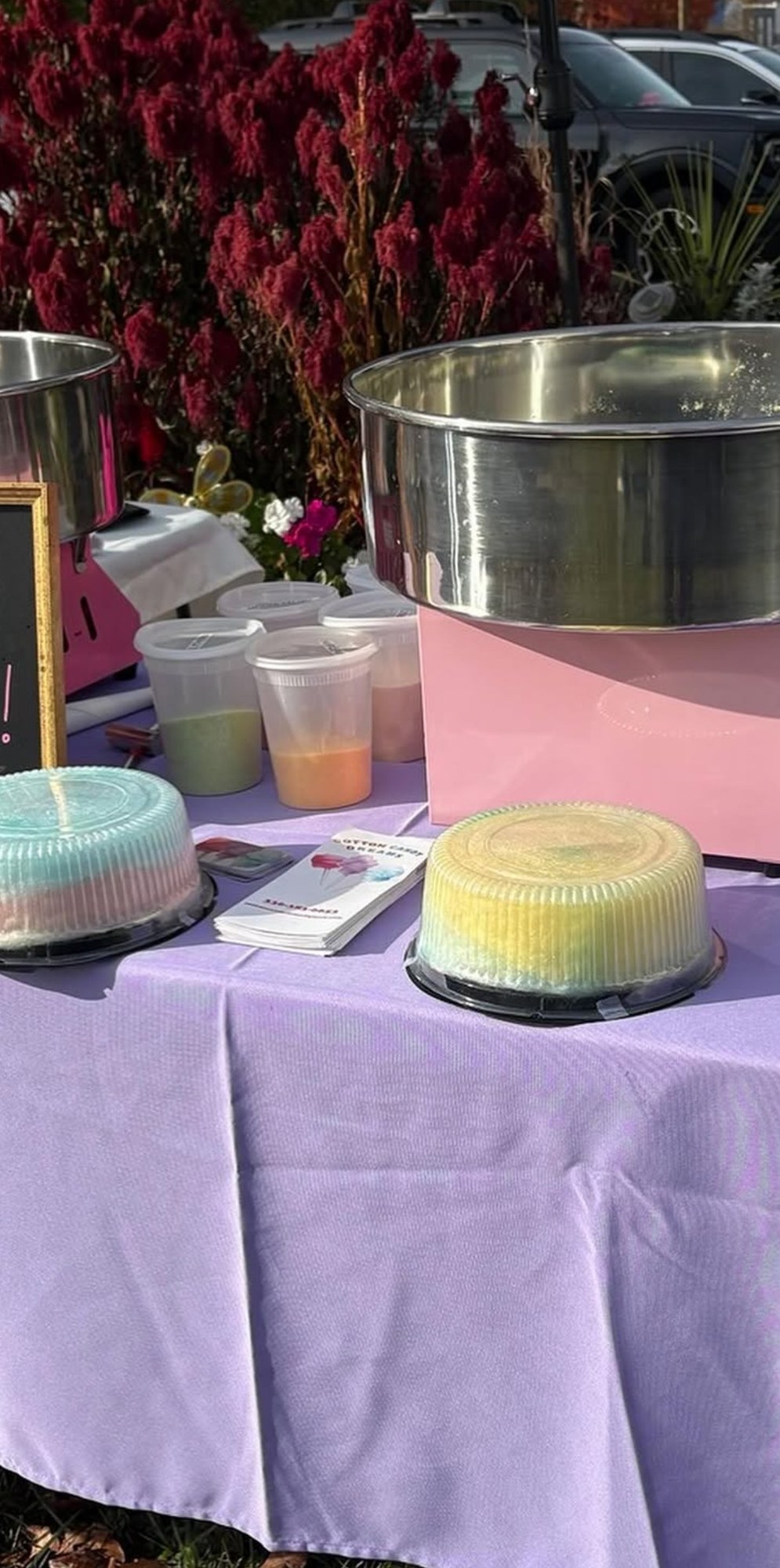 Cotton candy machines and colorful Dream Cakes ready for an outdoor event