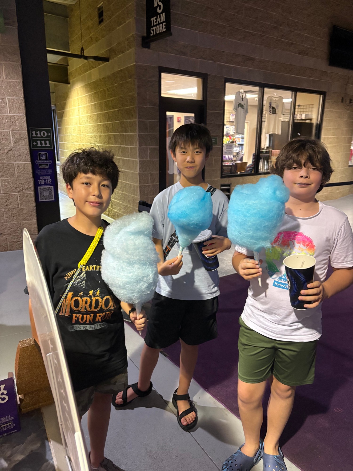 Friends enjoying blue cotton candy at a Winston-Salem Dash game
