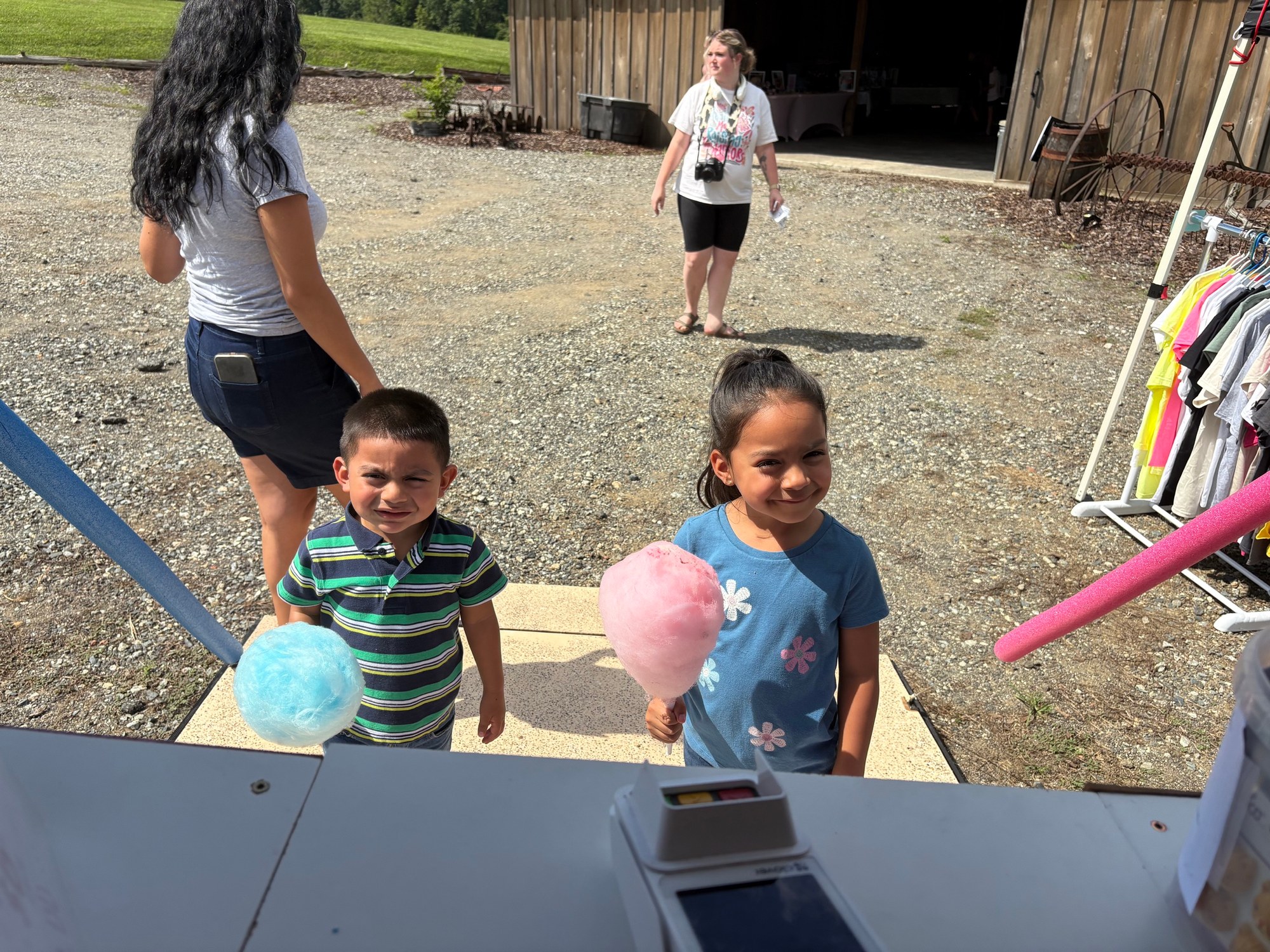 Young guests enjoying pink and blue cotton candy at a summer community event